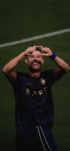 a man with his hands on his head in the middle of a soccer ball field