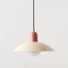 a white and pink light hanging from a ceiling fixture with a black cord attached to it