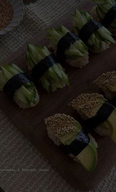 there are many sushi rolls on the wooden cutting board with black tape around them