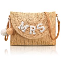 a straw bag with the word mrs on it and pom - pom ball