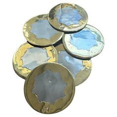 five metal plates stacked on top of each other with blue and gold paint in them