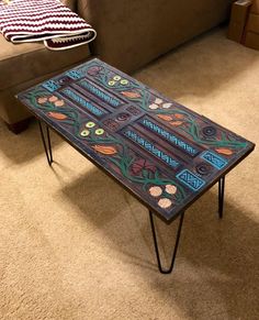 a table that is sitting on the floor in front of a couch with pillows and blankets