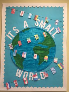 a bulletin board with the words it's a small world hanging on a line