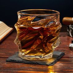 a glass filled with liquid sitting on top of a wooden table