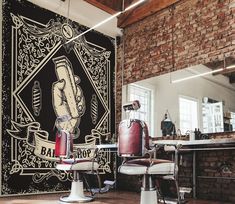 the interior of a barbershop with brick walls and exposed ceilings, decorated with artwork