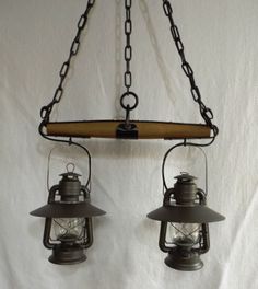 two old fashioned hanging lanterns on a white wall