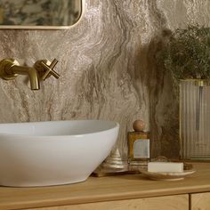 a white bowl sitting on top of a wooden counter next to a mirror and brush