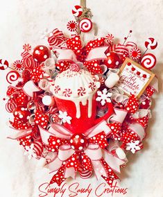 a red and white christmas wreath with a cupcake in the center surrounded by candy canes