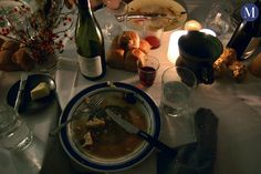 a dinner table is set with wine and food