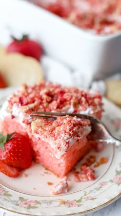 a piece of strawberry cake on a plate with a knife and fork next to it