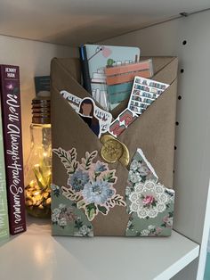 an open envelope with stickers on it sitting on a shelf next to some books