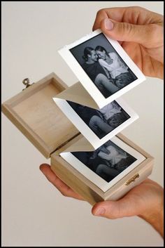 a person holding an open box with two photos in it