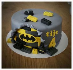 a batman themed birthday cake with legos on it's side and the number four