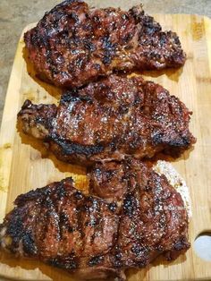 two pieces of meat sitting on top of a cutting board