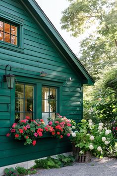 a green house with flowers in the window boxes