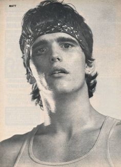 an old photo of a young man wearing a head band and looking at the camera