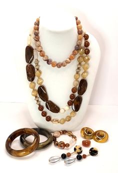 Vintage 70's to 90's Lucite Shades of Beige Brown Root Beer Coffee and Cream Necklace Earrings Bracelet Ring A curated collection of mix and match large earrings , chunky necklaces, beaded bracelet and bangle bracelets and one Lucite ring for good measure! 2 necklaces 2 bangle bracelets 2 pairs of earrings 1 beaded bracelet 1 ring These are vintage items, they have been cleaned, inspected and found to be in very good condition. Comes in a gift box ideal for gift giving and storage. Luxury Vintage Brown Necklace, Luxury Vintage Brown Necklaces, Retro Brown Jewelry For Gift, Retro Adjustable Brown Jewelry, Retro Brown Adjustable Jewelry, Vintage Brown Jewelry Gift, Vintage Brown Bracelets With Natural Stones, Vintage Brown Bracelet With Natural Stones, Retro Brown Beaded Jewelry