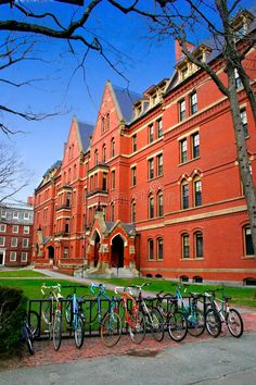 several bicycles are parked in front of an old red brick building on a sunny day