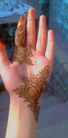 a woman's hand with hendix on it and flowers painted on the palm