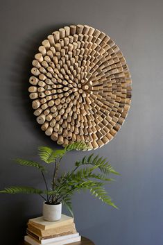 a plant sits on a table next to a circular wooden wall decoration with holes in it