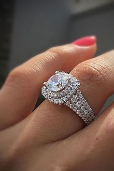 a woman's hand holding an engagement ring with two rows of diamonds on it