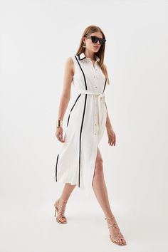 Feel Confident In Our Midi Dress, With A Shirt Style Design Featuring A Formal Collar, As Well As A Belted Waist For A Cinched Silhouette, And A Long, Flared Skirt. Style It With Block Heels Or Ankle Boots For A Look Perfect For Office Days, Then Wear It With Heeled Boots Or Strappy Heels For An Evening Look. Soft Tailored Pipe Detail Sleeveless Shirt Dress Flattering Fit And Flare Silhouette Unique Contrasting Lining V Neckline Formal Collar Detailing Belted Waist Feature Relaxed, Flared Skirt Black Shirt Dresses, White Shirt Dresses, Long Flared Skirt, Latest Dress For Women, Sleeveless Shirt Dress, Soft Tailoring, Shirt Dresses, White Shirt Dress, Black Shirt Dress