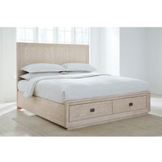 a bed with two drawers underneath it in a white room next to a large window