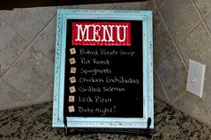 a menu board sitting on top of a granite counter next to a wall mounted light switch