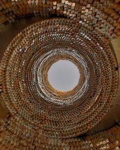 an overhead view of a circular sculpture made out of wooden blocks and metal strips with a white circle in the center