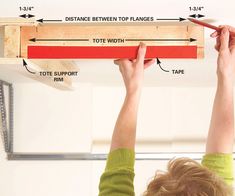 a woman is measuring the height of a ceiling beam with a tape measure ruler in front of her head