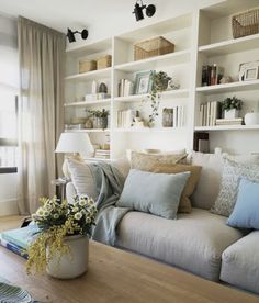 a living room filled with furniture and lots of books on the shelves next to a window