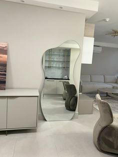 a living room filled with furniture and a large mirror on top of it's wall