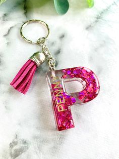 the letter p is decorated with pink glitter and tassels