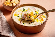 a bowl filled with soup next to a bowl of crackers