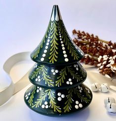 a ceramic christmas tree sitting on top of a table next to some white and brown decorations