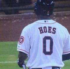 a baseball player standing on top of a field wearing a uniform and holding a bat