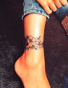 a woman's foot with a flower tattoo on her left ankle and the bottom part of her leg