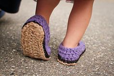 a close up of a person's feet wearing crocheted slippers