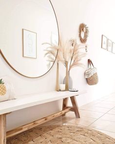 a white bench sitting in front of a round mirror on the side of a wall