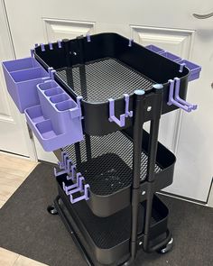 a black and purple cart with six trays on it's wheels in front of a door