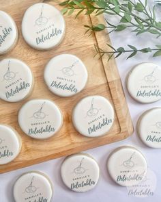 twelve personalized wedding cookies on a wooden tray