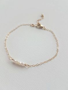 This delicate pearl bracelet looks so chic and stylish for every day wear or for a special occasion. Adorn yourself or bridesmaids in the natural, beautiful, luster of a fresh water pearl. Pick your preferred metal choice, with available options in sterling silver, 14k gold filled or 14k rose gold filled. The Details: - Featured: Four small fresh water pearls delicately hand wrapped using gold filled wire and adorned with delicate 14k gold filled cable chain.  - Contact us for custom bridesmaid Bridesmaid Jewelry Gold, Jewelry Gold Bracelet, Gold Bridesmaid Jewelry, Schmuck Gold, Gold Armband, Jewelry Bridesmaid, Etsy Bridesmaid Gifts, Wedding Jewelry Bracelets, Dainty Bracelets