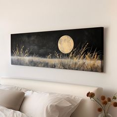 a painting hanging on the wall above a bed in a room with white sheets and pillows