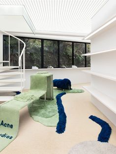 the interior of a modern house with white walls and carpeted flooring, stairs leading up to an upper level