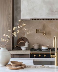 a white vase sitting on top of a kitchen counter next to a sink and stove