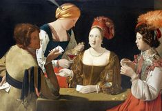 three women playing cards at a table with one woman holding a card in her hand