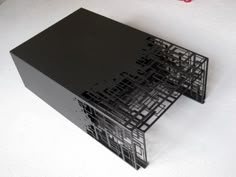 a black metal structure sitting on top of a white table