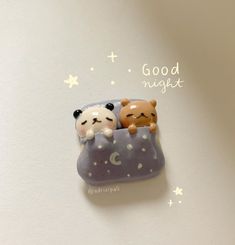 there are two small bears in a tiny bed on top of a table with the words good night written above it