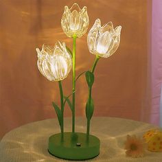 three glass tulips sitting on top of a table