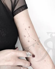 a woman's arm with a small star tattoo on the left side of her arm